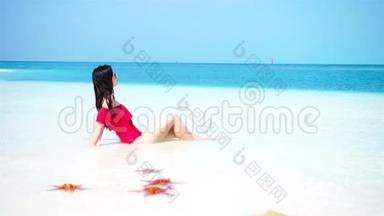 年轻漂亮的女人在热带海滨玩得很开心。 快乐的女孩享受热带度假的异国风情岛